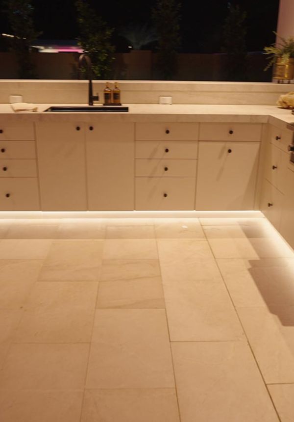 Close up of white outdoor cabinetry with warm under-cabinet lighting